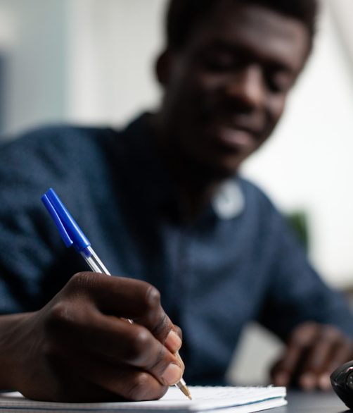 closeup-student-writing-marketing-strategy-notebook